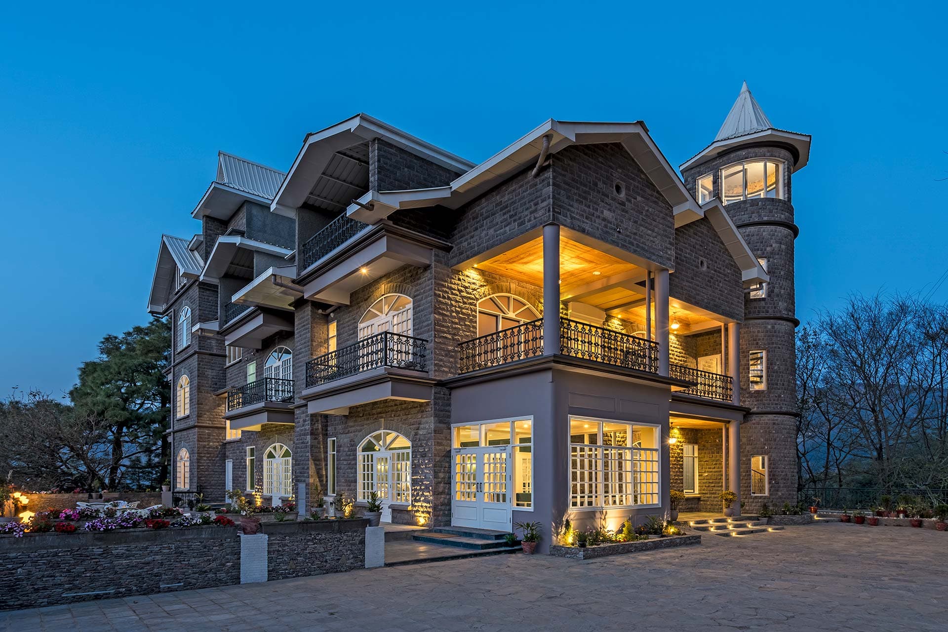 The Mansion at dusk, its turret lit against the hills